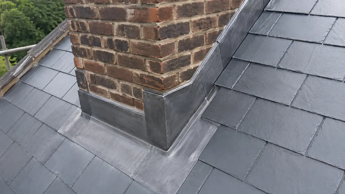 Lead flashing detail dressed around a brick chimney
